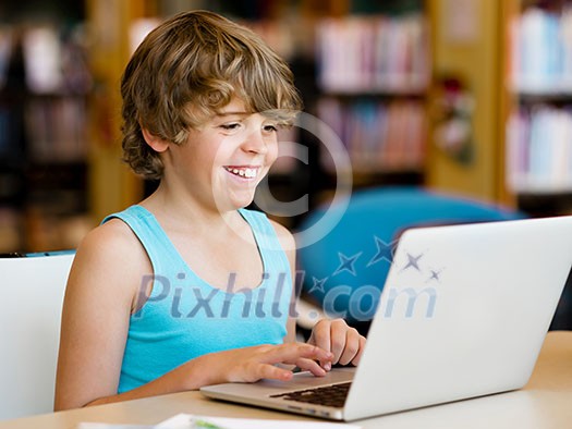 Little boy with laptop in library