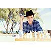 Elderly man sitting outdoors with chess