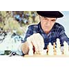 Elderly man sitting outdoors with chess