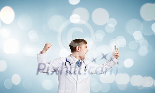 Young male doctor screaming in mobile phone emotionally