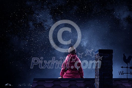 Cute kid girl sitting on house roof. Mixed media Cute kid girl sitting on house roof. Mixed media
