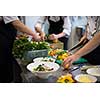 Professional team cooks and chefs preparing meals at busy hotel or restaurant  kitchen