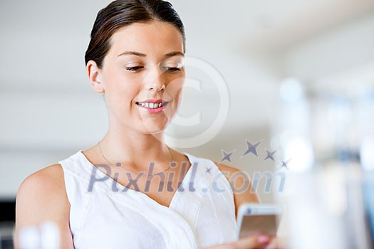 Portrait of young attractive woman holding mobile phone