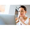 Young beautiful woman sitting at the table and working on her laptop