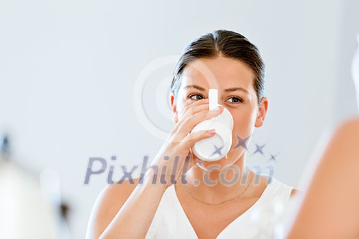 Young woman sitting at the kitchen table having tea with her friend Young woman sitting at the kitchen table having tea with her friend