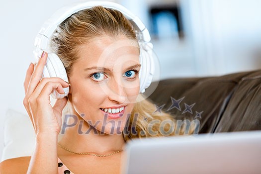 Young beautiful woman sitting on the sofa and working on her laptop