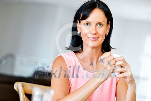 Attractive woman with cup of tea or coffee at home