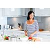Image of beautiful woman standing in the kitchen and smiling