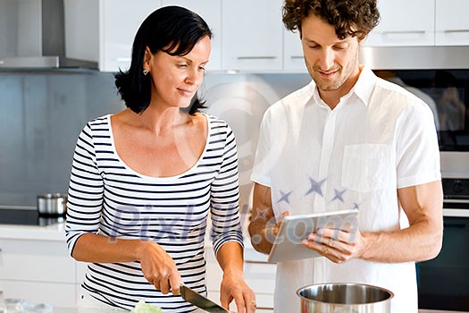 Couple cooking together in the modern kitchen at home Couple cooking together in the modern kitchen at home