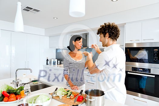 Couple cooking together in the modern kitchen at home Couple cooking together in the modern kitchen at home