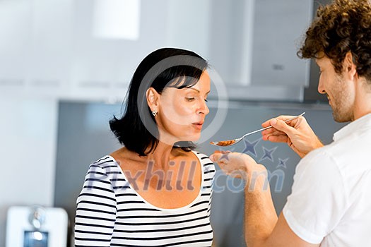 Couple cooking together in the modern kitchen at home Couple cooking together in the modern kitchen at home