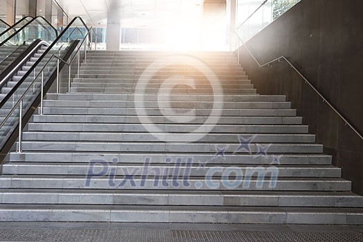 Concrete stairway and escalator in modern office building. Mixed media Concrete stairway and escalator in modern office building. Mixed media