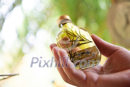 tincture or potion bottle in hand of herbalist bunch of dry healthy herbs in background alternative medicine tincture or potion bottle in hand of herbalist bunch of dry healthy herbs in background alternative medicine