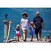 happy grandparents with cute little granddaughters having fun holding their hands while walking  by the sea during Summer vacation  Healthy family holiday concept