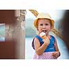 adorable little girl eating ice cream on beach by the sea during Summer vacation