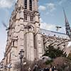 Paris, France - August 04, 2006: Street with tourist attraction Notre Dame cathedral on a summer day against a blue sky with tourists and pigeons