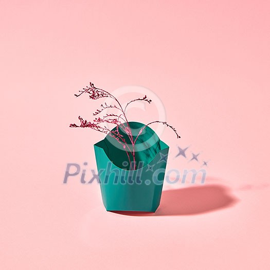 Red painted branch in a cardboard green box presented on a pink background with copy space. Postcard Red painted branch in a cardboard green box presented on a pink background with copy space. Postcard