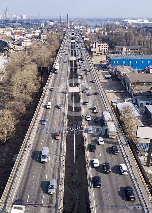 Aerial view from drone traffic overpass with moving cars and trucks on an asphalt road in a sunny spring day. Aerial view from drone traffic overpass with moving cars and trucks on an asphalt road in a sunny spring day.
