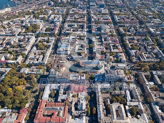 Aerial view of a drone on the city of Odessa with a shopping center, streets with cars and buildings on a sunny summer day, Ukraine.