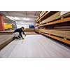 young man carpenter measuring wooden board for cutting while working in big modern carpentry High quality wood concept