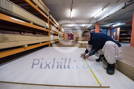 young man carpenter measuring wooden board for cutting while working in big modern carpentry High quality wood concept young man carpenter measuring wooden board for cutting while working in big modern carpentry High quality wood concept