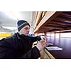 young man carpenter using pen while writing a receipt  in big modern carpentry