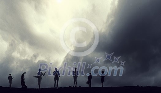 Silhouettes of business people against gray sky background