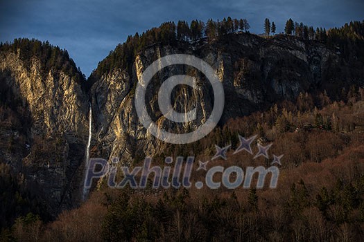 High waterfall within alpine scenery in Switzerland High waterfall within alpine scenery in Switzerland