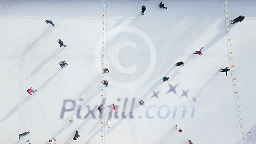 Outdoor ice skating rink with people riding on a winter day. Aerial view from the drone. Outdoor ice skating rink with people riding on a winter day. Aerial view from the drone.
