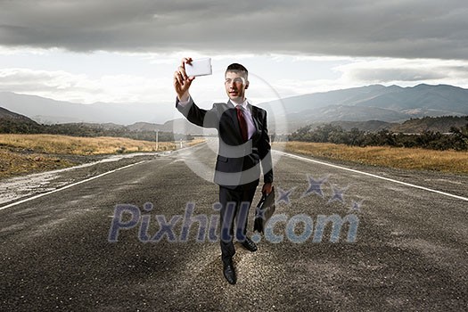 Businessman taking selfie from smartphone. Mixed media Businessman taking selfie from smartphone. Mixed media