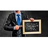 Handsome businessman holding wooden frame with business sketches. Mixed media