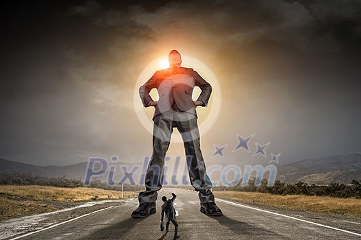 Low angle view of businessman looking like giant. Mixed media