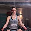 Relaxed young sportswoman doing yoga exercise and meditating in a fitness studio