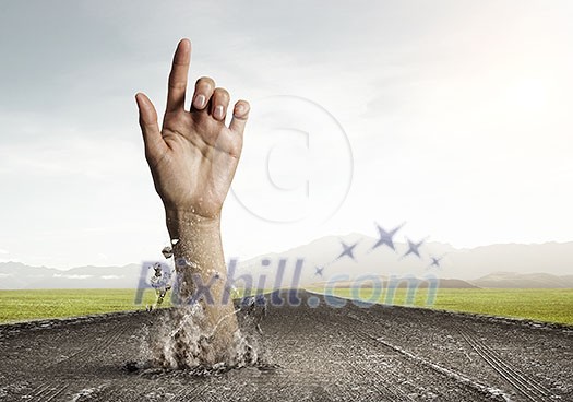 Hand coming out of ground as concept for never give up Hand coming out of ground as concept for never give up