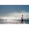 Young relaxed businessman at seaside looking far away at sea. Mixed media