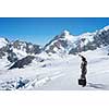 Businessman in suit among snowy mountains ready to overcome any challenge. Mixed media