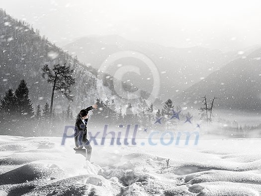 Businessman in suit among snowy mountains ready to overcome any challenge. Mixed media