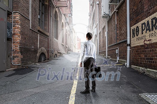 Businessman standing on city street. Mixed media Businessman standing on city street. Mixed media