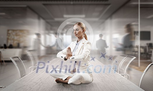 Attractive office woman sitting cross legged at workplace. Mixed media Attractive office woman sitting cross legged at workplace. Mixed media