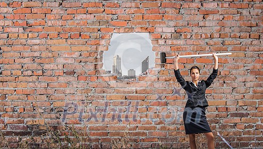 Businesswoman with hammer and hole in stone wall. Mixed media