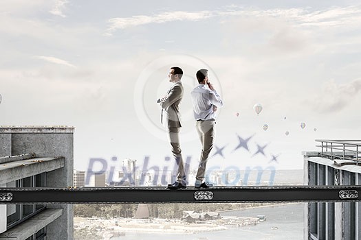 Two businessmen standing back to back and looking away. Mixed media Two businessmen standing back to back and looking away. Mixed media