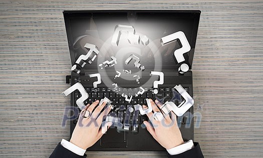 Top view of businesswoman using laptop and question marks
