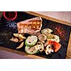 Juicy grilled steak with vegetables on a wooden board