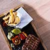 Juicy grilled steak with vegetables on a wooden board