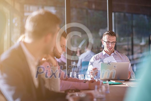 Group of a young business people brainstorming and discussing business plan on meeting at sunny bright office interior Group of a young business people brainstorming and discussing business plan on meeting at sunny bright office interior