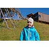portrait of a young boy with blue jacket and hat on sunny day in nature under alpine coaster