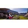 Excited young couple driving alpine coaster while enjoying beautiful sunny day in the nature