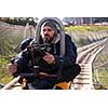 young videographer with gimball video slr at work on alpine coaster