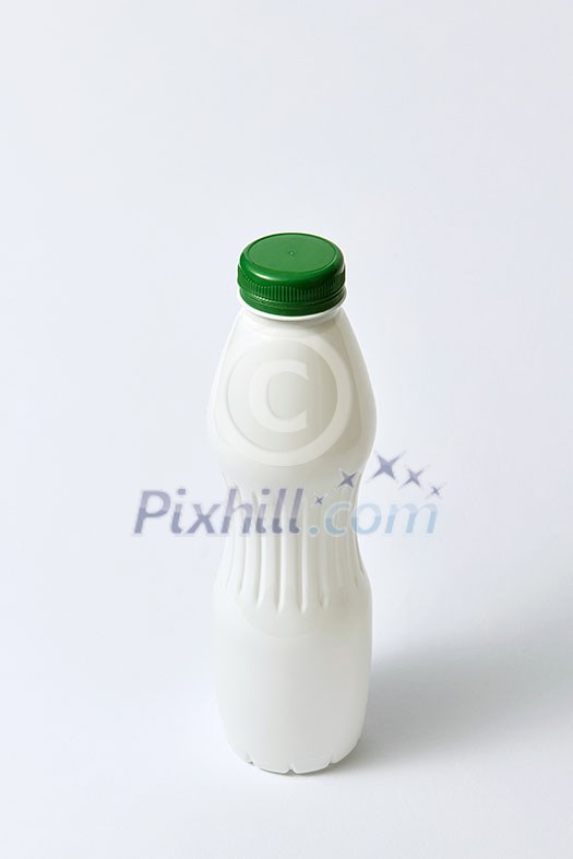 White empty bottle mockup with green top for dairy products on a light gray background, copy space. White empty bottle mockup with green top for dairy products on a light gray background, copy space.