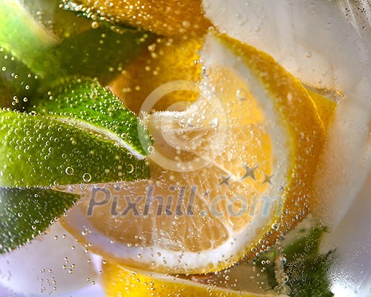 Slices of lemon and lime with bubbles of water in a glass. Macro photo of refreshing lemonade Slices of lemon and lime with bubbles of water in a glass. Macro photo of refreshing lemonade